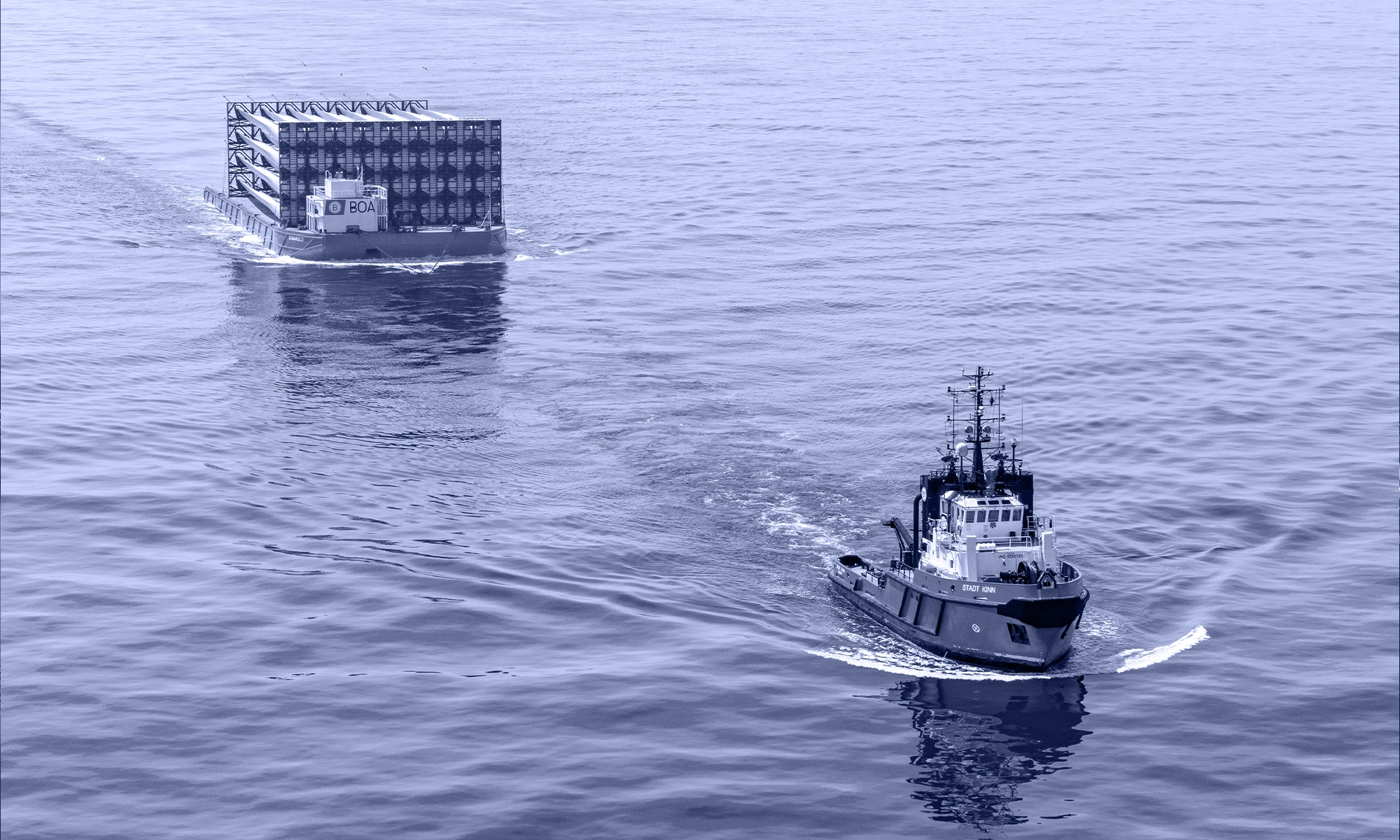 Tug boat Stadt Kinn towing a barge loaded with blades for offshore wind turbines • Boluda Towage